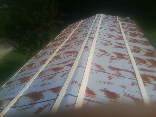 Rusted metal roof panels with new wood purlins before replacement — Storm Damage Roof Repair in Sula by Roofing Brothers